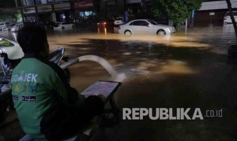 Pengemudi Gojek menunggu banjir reda di kawasan Kemang, Jakarta, hingga Ahad (28/8) dinihari. 