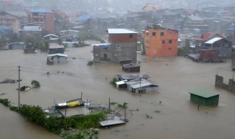 Banjir merendam sejumlah rumah di Kota Bauguio akibat imbas Topan Koppu di utara Filipina, Senin (19/10).