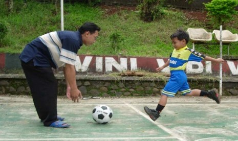 Bapak dan Anak Main bola di Lapangan (ilustrasi).