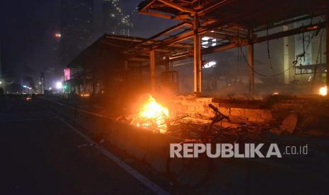 Bara api dan asap mengepul dari sisa bangunan halte Transjakarta di Bundaran HI, Jakarta, Kamis (8/10). Halte yang menjadi akses ke stasiun MRT ini hangus dibakar massa yang dipukul mundur dari area bundaran Bank Indonesia.