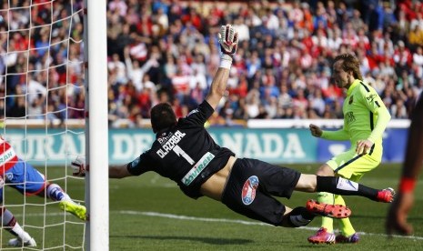 Barcelona's Ivan Rakitic (R) scores a goal past Granada's goalkeeper Oier Olazabal during their Spanish first division soccer match at Nuevo Los Carmenes stadium in Granada February 28, 2015