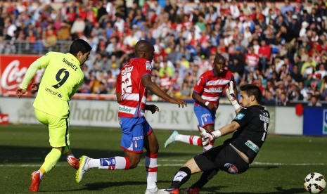 Barcelona's Luis Suarez (L) scores past Granada's goalkeeper Oier Olazabal during their Spanish first division soccer match at Nuevo Los Carmenes stadium in Granada February 28, 2015.