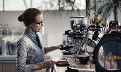 Barista menyeduh kopi di kedai kopi.