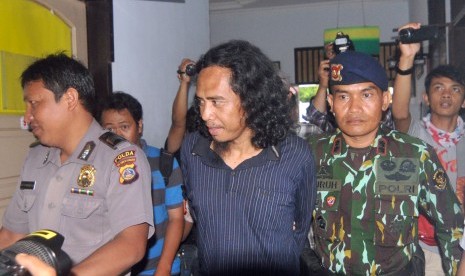 Basri alias Bagong (tengah) salah satu anggota kelompok bersenjata Santoso Mujahidin Indonesia Timur (MIT) ketika digiring mememasuki ruangan pemeriksaan kesehatan di RS. Bhayangkara, Palu, Sulawesi Tengah, Rabu (14/9).