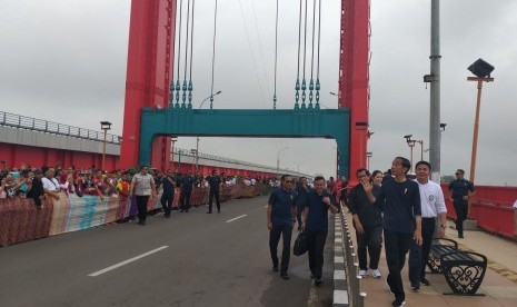 BATIK -- Batik sepanjang 250 meter dibentangkan di sepanjang Jembatan Ampera Palembang untuk menyambut Presiden Jokowi, Sabtu (9/3).