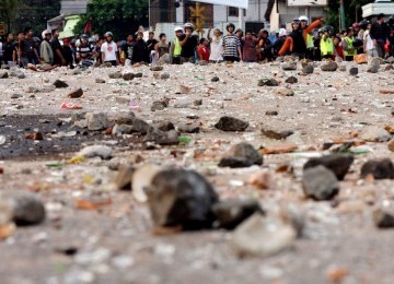 Batu berserakan usai tawuran antar warga pasar Rumput dan warga Menteng Tenggulun di Jakarta Selatan, Minggu (3/7). 