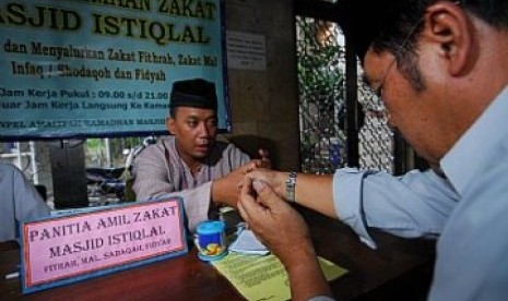 Sebagian masyarakat melakukan ijab kabul salaman saat bayar zakat. Bayar zakat, ilustrasi