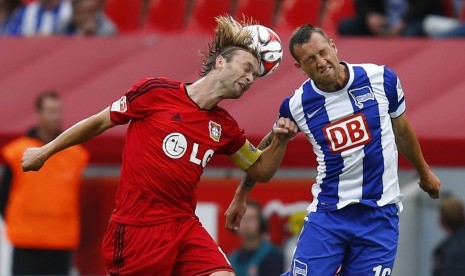 Bayer Leverkusen's Simon Rolfes (L) and Hertha BSC Berlin's Julian Schieber fight to head the ball during the German first division Bundesliga soccer match in Leverkusen August 30, 2014.