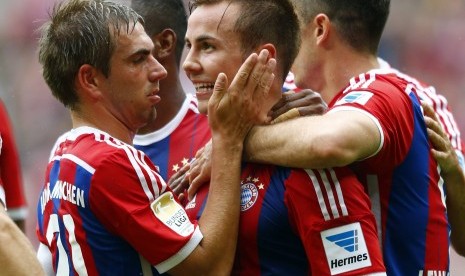 Bayern Munich's Mario Goetze celebrates with Philipp Lahm (L) after he scored against VfB Stuttgart during their German first division Bundesliga soccer match in Munich September 13, 2014.