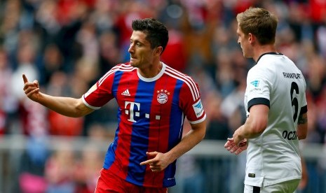 Bayern Munich's Robert Lewandowski (L) celebrates near Eintracht Frankfurt's Bastian Oczipka after scoring a goal during their German Bundesliga first division soccer match in Munich April 11, 2015.