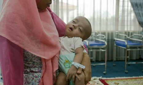 Bayi berusia empat bulan bernama Gibran digendong oleh ibunya di Posko Evakuasi Korban Asap di Kantor Wali Kota Pekanbaru, Riau, Rabu (30/9).