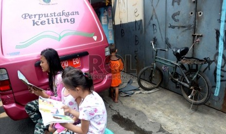 Beberapa anak membaca di perpustakaan keliling di Jakarta, Ahad (27/9).