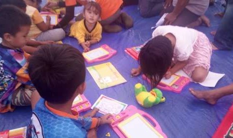 Beberapa anak tengah asyik menggambar di dalam kelas darurat yang didirikan Kemendikbud. Kelas darurat didirikan di camp pengungsian Petobo, Kota Palu.