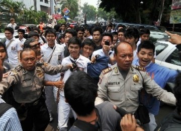 Beberapa anggota Kepolisian menahan sejumlah siswa SMAN 6 yang akan menyerang wartawan, Senin (19/9). 