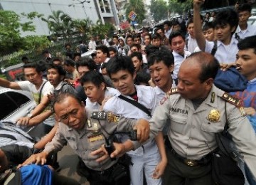 Beberapa anggota Kepolisian menahan sejumlah siswa SMU 6 yang akan menyerang di Blok M, Jakarta, Senin (19/9).