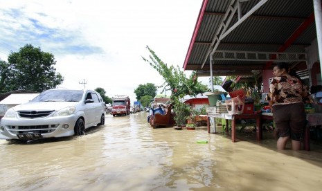 Beberapa kendaraan melaju melewati banjir di jalan Trans Sulawesi, Limboto, Kabupaten Gorontalo, Rabu (26/10). 