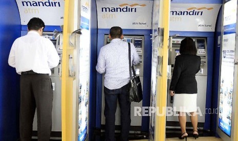 Nasabah tengah mengambil dana tunai dari mesin ATM Mandiri.  (ilustrasi)