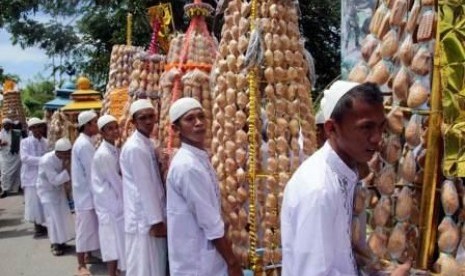 Beberapa orang santri mengusung kue walima saat perayaan maulid Nabi Muhammad SAW