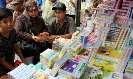 Beberapa orang tua mencari buku tulis untuk anaknya di Pasar Jatinegara, Jakarta, Jumat (13/7). 