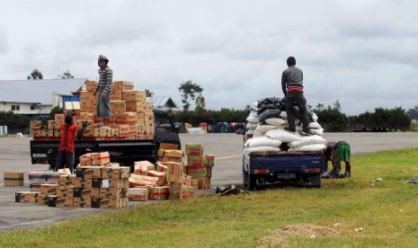 Beberapa pekerja sedang mengangkut sejumlah barang ke atas kendaraan usai didatangkan dari jayapura dengan menggunakan pesawat cargo di Bandara Wamena, Jumat (9/12).