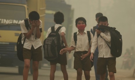   Beberapa pelajar SMP 15 Kota Jambi berjalan pulang menembus kabut asap dari sekolah di Jalan Lingkar Timur, Jambi, Selasa (29/9).