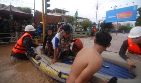   Beberapa petugas Palang Merah Indonesia (PMI) Sulut menggunakan perahu karet ketika membantu warga menyeberangai banjir di Kelurahan Wenang, Manado, Sulawesi Utara, Rabu (15/1).   (Antara/Fiqman Sunandar)