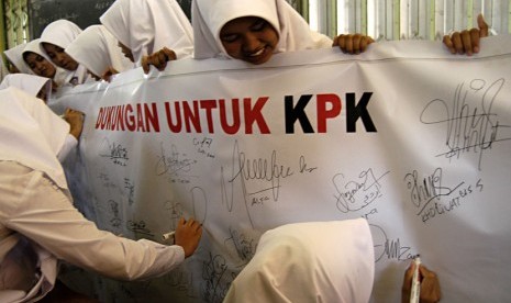  Beberapa siswa Madrasah Aliyah membubuhkan tanda tangan sebagai dukungan mereka terhadap KPK di Pondok Pesantren Islam Ash Shidiqi Putri, Kaliawates, Jember, Jawa Timur, Senin (8/10).  (Seno S./Antara)