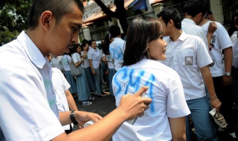  Beberapa siswa melakukan aksi corat-coret saat pengumuman kelulusan Ujian Nasional (UN) tingkat SMA/MA di SMA Negeri 1 Jakarta, Sabtu (26/5). (Prayogi/Republika)