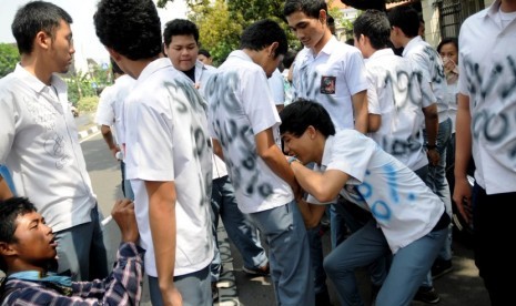  Beberapa siswa melakukan aksi corat-coret saat pengumuman kelulusan Ujian Nasional (UN) tingkat SMA/MA di SMA Negeri 1 Jakarta, Sabtu (26/5). (Prayogi/Republika)