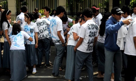  Beberapa siswa melakukan aksi corat-coret saat pengumuman kelulusan Ujian Nasional (UN) tingkat SMA/MA di SMA Negeri 1 Jakarta, Sabtu (26/5). (Prayogi/Republika)