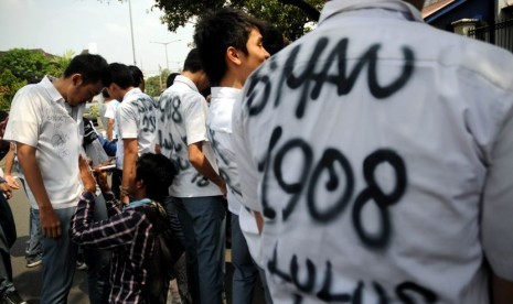  Beberapa siswa melakukan aksi corat-coret saat pengumuman kelulusan Ujian Nasional (UN) tingkat SMA/MA di SMA Negeri 1 Jakarta, Sabtu (26/5). (Prayogi/Republika)