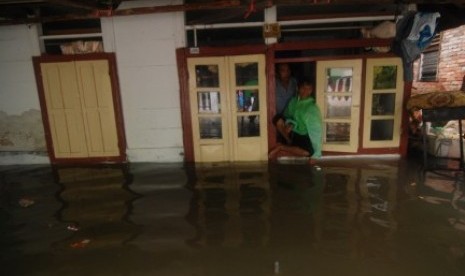 Beberapa warga berada dirumahnya yang dilanda banjir di kelurahan Mahakam Lingkungan IV, kecamatan Singkil, kota Manado, Sulawesi Utara.