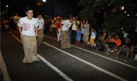  Beberapa warga negara asing mengikuti lomba balap karung di Jalan Jaksa, Jakarta. ilustrasi