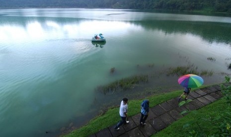 Beberapa wisatawan lokal berjalan dipinggir Danau Linow, kota Tomohon, Sulawesi Utara