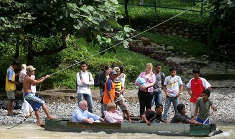 Beberapa wisatawan lokal maupun mancanegara menyeberang menggunakan perahu kayu (getek) di kawasan Objek Wisata Alam Bukit Lawang, Bahorok, Kab Langkat, Sumut, Kamis (17/5).