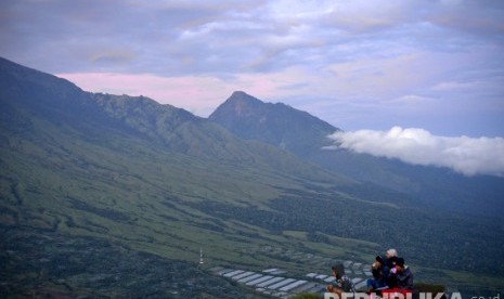 Beberapa wisatawan menikmati matahari terbit Gunung Rinjani dari Bukit Pergasingan, Sembalun, Lombok.   (Republika/ Wihdan Hidayat)