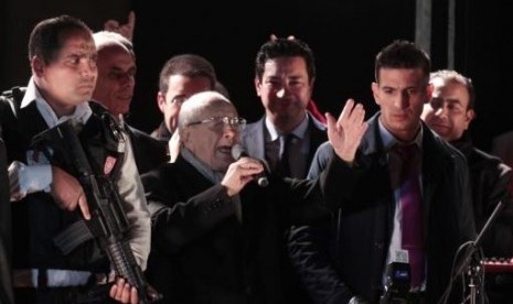 Beji Caid Essebsi (center), Nidaa Tounes party leader, gestures outside the party headquarters in Tunis December 21, 2014.