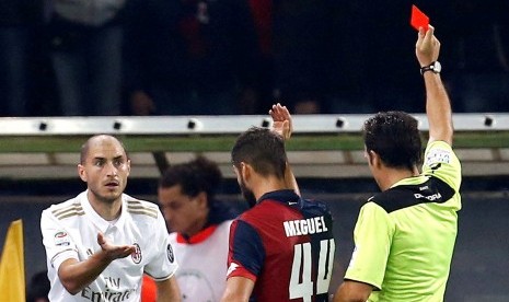 Bek AC Milan, Gabriel Paletta (kiri) menerima kartu merah dari wasit Luca Banti pada laga Serie A lawan Genoa, di stadion Luigi Ferraris, Rabu (26/10) dini hari WIB. Pada laga itu, Milan kalah 0-3.