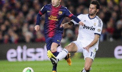 Bek Alvaro Arbeloa mencoba mengadang Andres Iniesta.