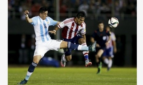 Bek Argentina Ramiro Funes Mori (kiri) melanggar penyerang Paraguay Dario Lezcano