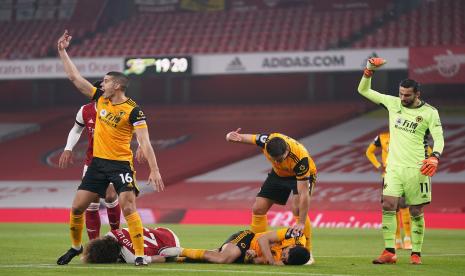 Bek Arsenal David Luiz (kiri bawah) dan bomber Wolves Raul Jimenez (kanan bawah) terkapar setelah beradu kepala ketika kedua tim bertandinga di Stadion Emirates, Senin (30/11).