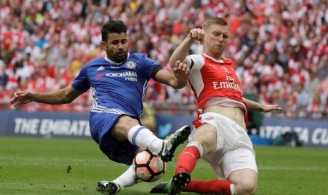 Bek Arsenal Per Mertesacker (kanan) saat menghentikan penyerang Chelsea Diego Costa.