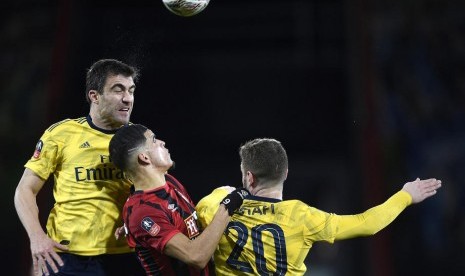 Bek Arsenal Shkodran Mustafi (kanan) dan Sokratis (kiri) berduel bola dengan pemain Bournemouth Dominic Solanke pada laga babak keempat Piala FA di Bournemouth, Selasa (28/1) pagi WIB, Arsenal mengalahkan Bournemouth 2-1.