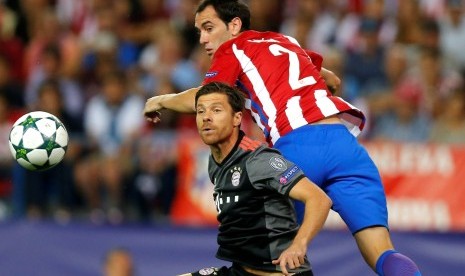 Bek Atletico Madrid, Diego Godin (kanan) berduel udara dengan gelandang Bayern Muenchen, Xabi Alonso pada laga Grup D Liga Champions, Kamis (29/9) dini hari WIB. Pada laga di Vicente Calderon itu, Atletico menang tipis 1-0.