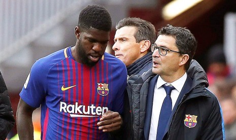 Bek Barcelona Samuel Umtiti (kiri) meninggalkan lapangan ketika mengalami cedera pada pertandingan timnya menghadapi Celta Vigo di Camp Nou, Barcelona, Spanyol, Sabtu (2/12). 