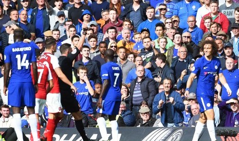 Bek Chelsea David Luiz (kanan) diusir keluar oleh wasit Michael Oliver setelah melakukan tekel keras kepada Sead Kolasinac pada pertandingan Liga Primer antara Chelsea dan Arsenal di Stamford Bridge, Ahad (17/9). 