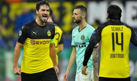 Bek Dortmund Matt Hummels merayakan kemenangan dengan rekan setimnya Nico Schulz di Signal Iduna Park, Rabu (6/11) dini hari WIB. 