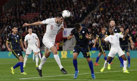 Bek Inggris Michael Keane menanduk bola saat menghadapi Kosovo.