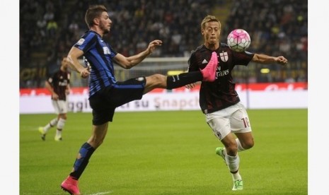 Bek Inter Milan Davide Santon (kiri) berebut bola dengan gelandang AC Milan Keisuke Honda.