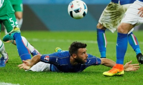 Bek Italia Andrea Barzagli terjatuh saat dilanggar.